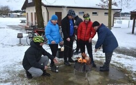 Pięć os&oacute;b piekących kiełbasy nad ogniskiem