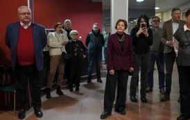 Stojących dziesięć os&oacute;b, w tle wieszak