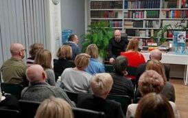 Mężczyzna siedzący naprzeciw grupy siedzących os&oacute;b