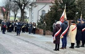 Poczty sztandarowe i orkiestra dęta przy rzeźbie żołnierza