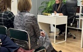 M&oacute;wiąca kobieta siedząca za biurkiem