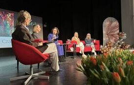Pięć kobiet siedzących na scenie