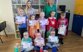 Ośmioro przedszkolak&oacute;w prezentuje dyplomy w asyście dw&oacute;ch kobiet