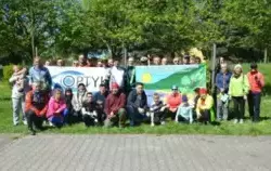 Rowerzyści z banerem rajdu i sponsora ustawieni do wspólnej fotografii