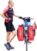 Rowerzysta z rowerem Rowerzysta trzymający rower z sakwami
