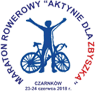 Rowerzysta z okręgu rowerowym z napisu Maraton Rowerowy Aktywnie dla Zbyszka