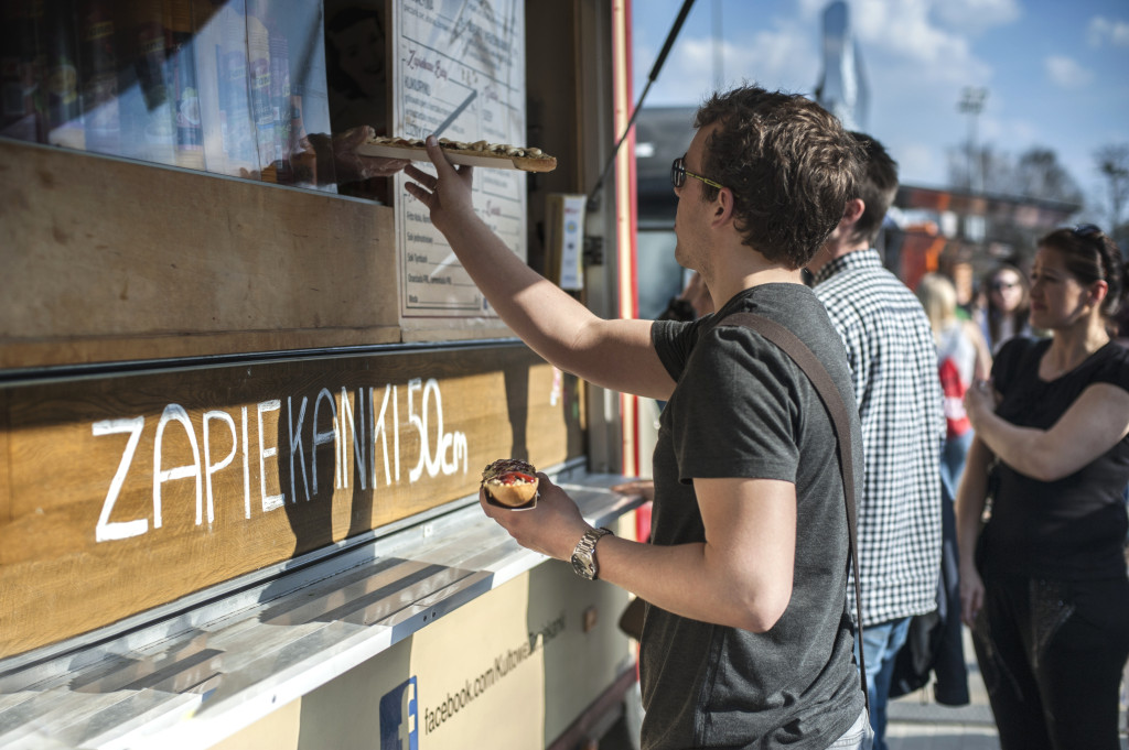 Mężczyzna odbierający zapiekankę z&nbsp;food trucka