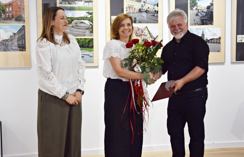 Stojący mężczyzna i&nbsp;dwie kobiety, z&nbsp;kt&oacute;rych jedna trzyma bukiet kwiat&oacute;w