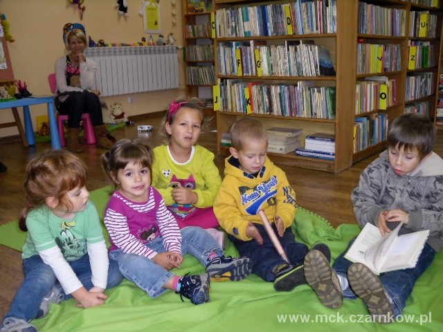 Zdjecie 1 Siedzące dzieci na dywanie w bibliotece