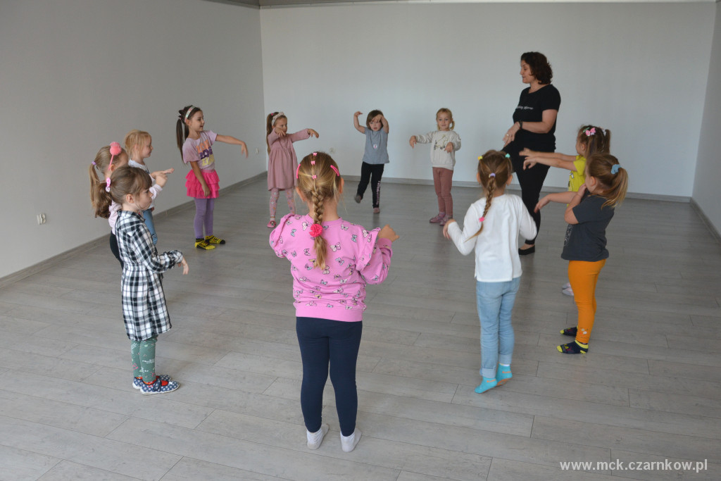 Grupa jedenastu dziewcząt tańcząca z instruktorką