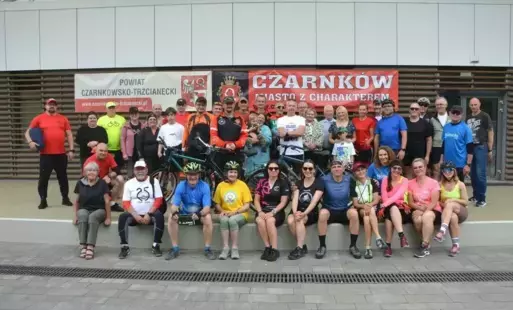 Rowerzyści z trzema rowerami ustawieni w dwóch rzędach do wspólnego zdjęcia