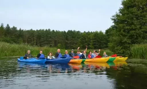 Kajakarze na rzece na tle lasu