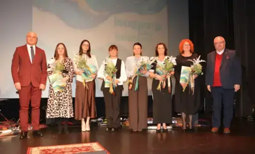 Sześć kobiet stojących z kwiatami pomiędzy dwoma mężczyznami