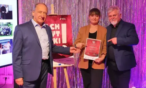 Kobieta i dwóch mężczyzn wskazujących na zapisaną kartkę papieru