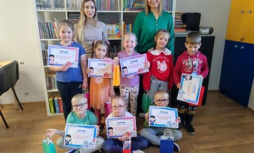 Ośmirio dzieci prezentuje dyplomy w asyście dwóch kobiet