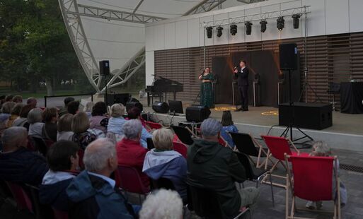 Żeńsko-męski duet na scenie przed widzami  na plażowych leżakach