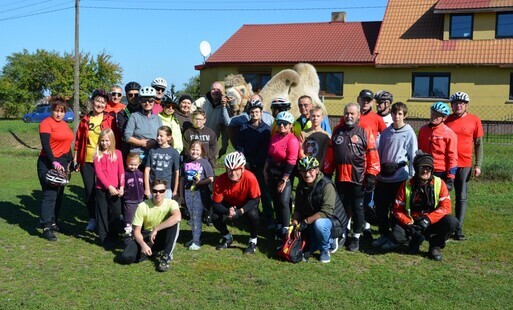 Rowerzyści ustawieni do wspólnego zdjęcia z wielbłądem